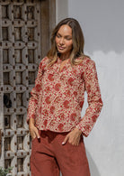 Woman wearing a 100% cotton top in cream based floral print with V neckline