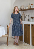 Woman wearing a navy blue based floral print cotton dress with pockets
