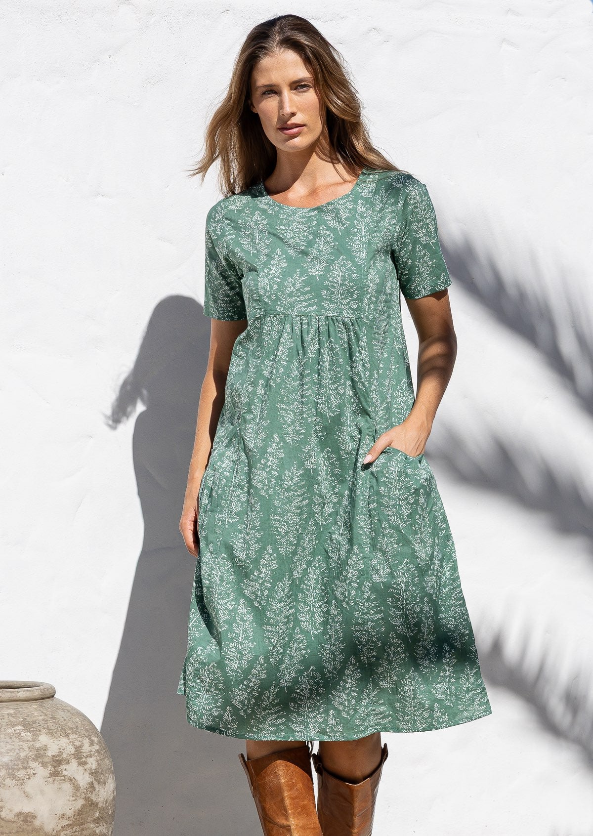 Woman posing in cotton over the knee length relaxed fit sun dress with short sleeves, with her hand in a pocket