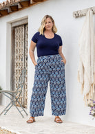 Woman wearing a 100% cotton wide leg pants in navy based floral print with high waist elastic and both hand in pockets
