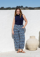 Woman wearing a 100% cotton wide leg pants in navy based floral print with pockets and pleats at the ankle.