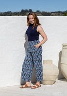 Woman wearing a 100% cotton wide leg pants in navy based floral print with high waist elastic and both hand in pockets