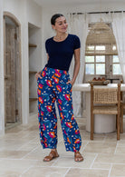 Woman wearing a basic top and royal blue based floral print wide leg cotton pants with pleated ankles, elastic waist and pockets