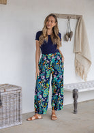 Woman wearing a 100% cotton wide leg pants in navy based multicolour floral print