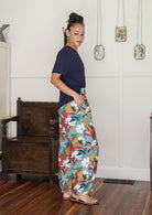 Model stands sideways wearing a basic top paired with printed wide leg cotton pants featuring pleated ankles and pockets