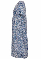 Side view of cotton dress with round neckline and short sleeves in white based blue floral print. 
