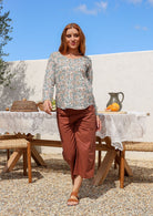 Model wearing a flattering long sleeve top with white based florals with plain pants.