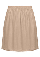 Nude toned slight A-line cotton slip skirt with elasticated waist and picot trim on hem, back view