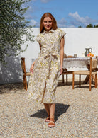 Woman wearing a 100% cotton cream floral-print midi shirt dress with tie waist. 