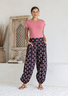 Model wears cotton harem pants with elasticated ankles, wide waistband and deep pockets.