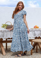 Blue and white floral print maxi dress with short sleeves and V-neck, on model outdoors