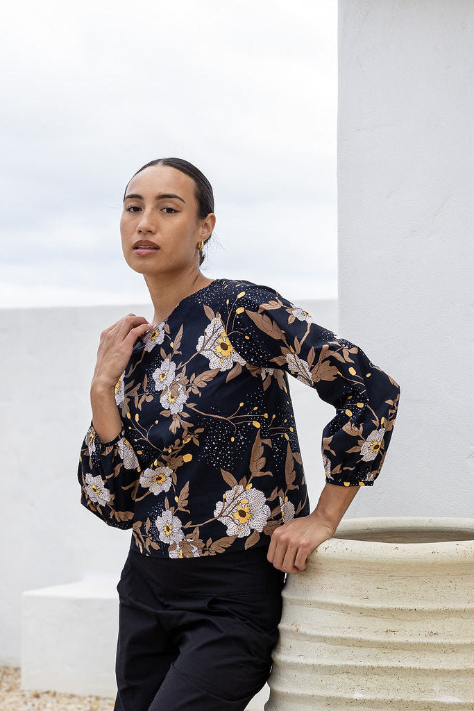 Woman wearing a floral top against a white background