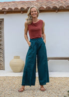Woman wearing a terracotta sleeveless basic top and teal wide-leg cotton pants with drawstring, elasticated waist and pockets