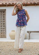Woman wearing a floral cotton top and  100% cotton wide leg pant in natural white with drawstring waist tie, pockets and elastic waist