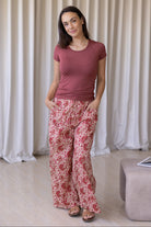 Model wears wide leg cotton floral printed pants with drawstring and hand in deep pockets.