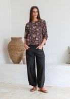 Model wears loose fit cotton top in black Indian traditional style floral print with black pants