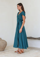 Woman wearing a teal rayon wrap maxi dress with short sleeves