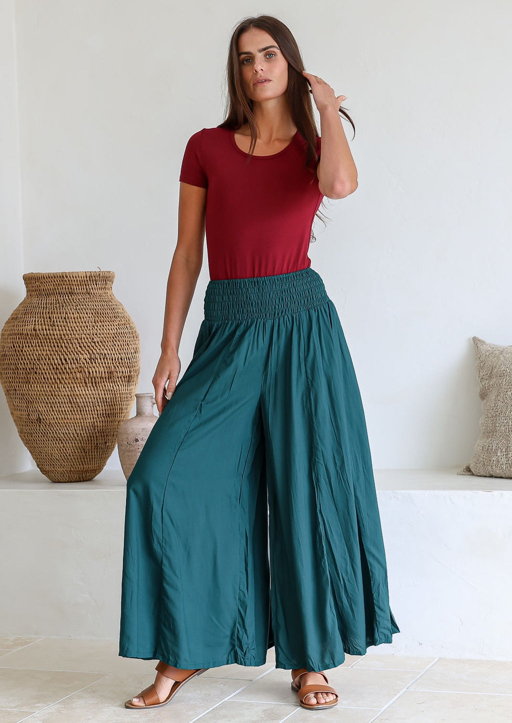 Woman wearing a maroon top and teal wide-leg rayon pants with a wide ruched waistband