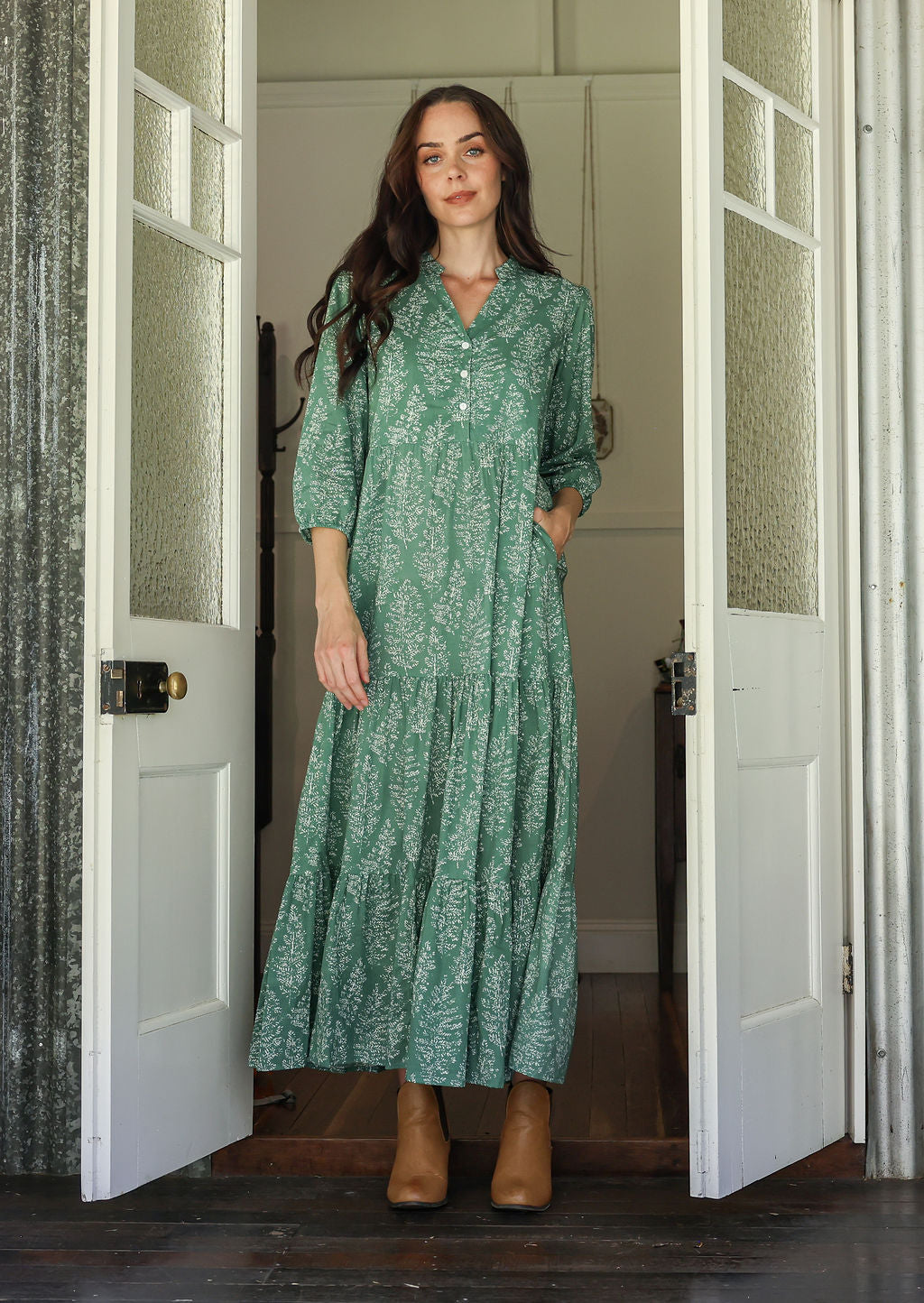 Woman wearing a 100% cotton tiered maxi dress in floral print with 3/4 sleeves, pockets and mandarin collar