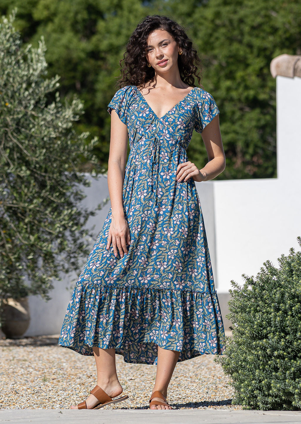 Model wearing 100 percent rayon maxi dress with elasticised cross-over bodice and tier at the bottom of the dress.
