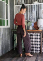 Woman standing backwards in cotton corduroy wide-leg dark brown pants