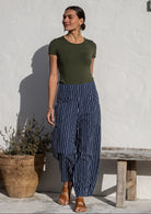 Woman wearing cotton wide leg pants in navy based white striped print with pockets paired with basic top 
