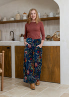 Woman wearing a 100% cotton velvet floral pants with wide waistband and a side zip