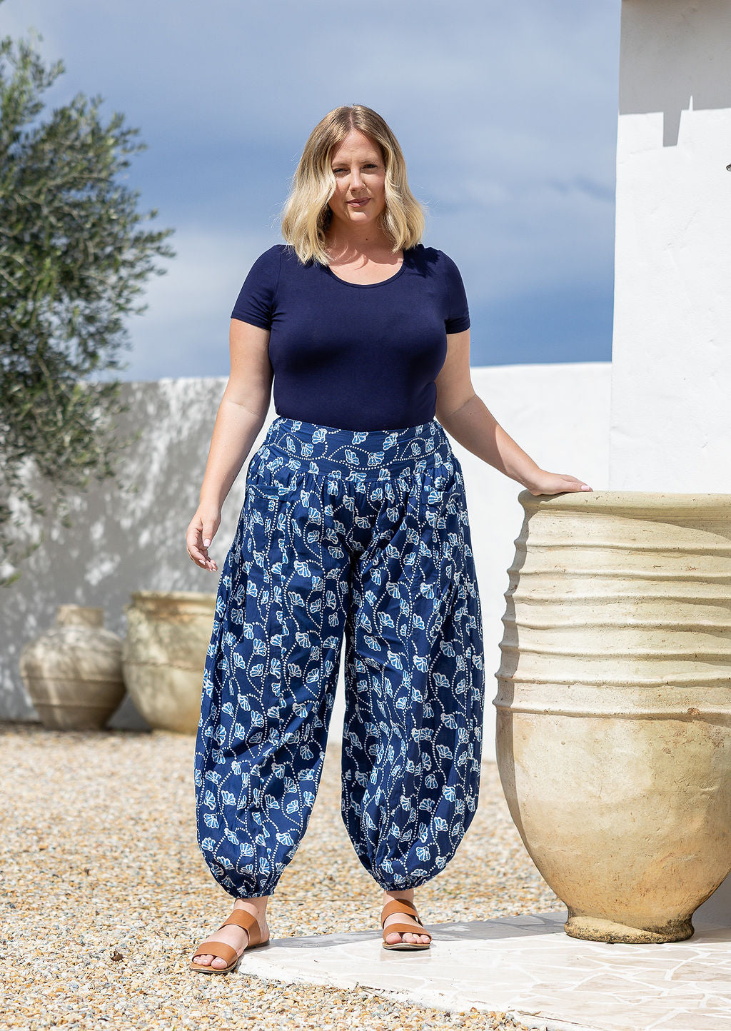 Model wears cotton harem pants with elasticated ankles, wide waistband and deep pockets.