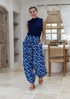 Model wears cotton harem pants with elasticated ankles, wide waistband and deep pockets.