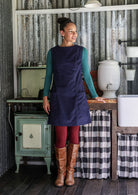 Woman wearing cotton corduroy tunic in navy blue with boat neck and front pockets