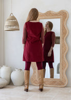 Woman standing backwards wearing cotton corduroy tunic in cabernet 