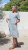 Video of woman in a blue based cotton floral short sleeve dress with round neckline