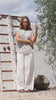 Video of a woman wearing a 100% cotton white based floral top paired with a plain white pants