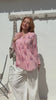 Video of a woman wearing a 100% cotton Pink striped floral long-sleeve blouse with pleated front. 