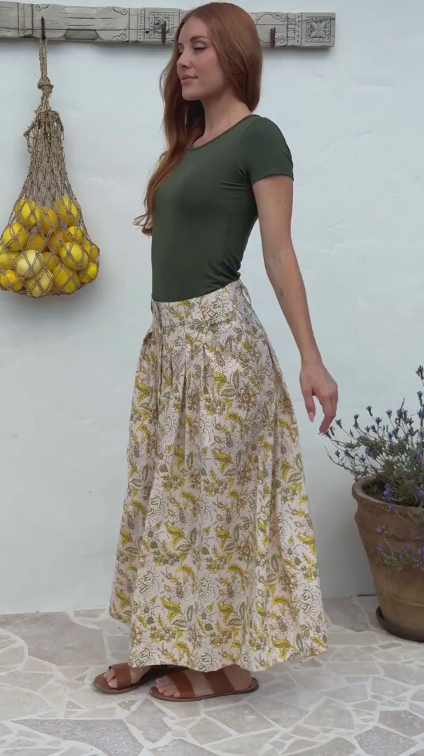 Video of a woman wears 100% cotton button through skirt in cream based floral print. 