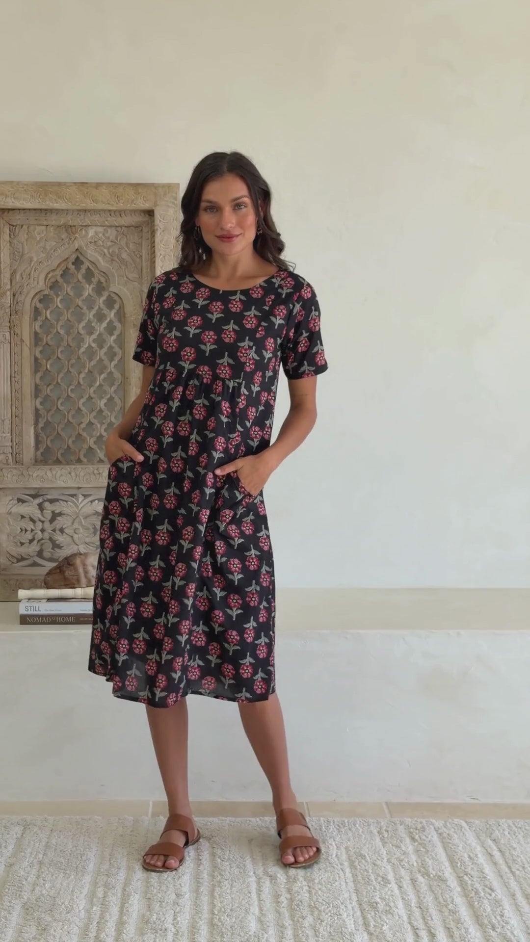 video of woman in black cotton floral sundress with sleeves and pockets