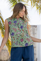 Woman wears 100% cotton moss green based floral print cotton sleeveless top with small gathers across the bust