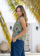 Model is wearing 100% cotton sleeveless  top in moss green based floral print. 