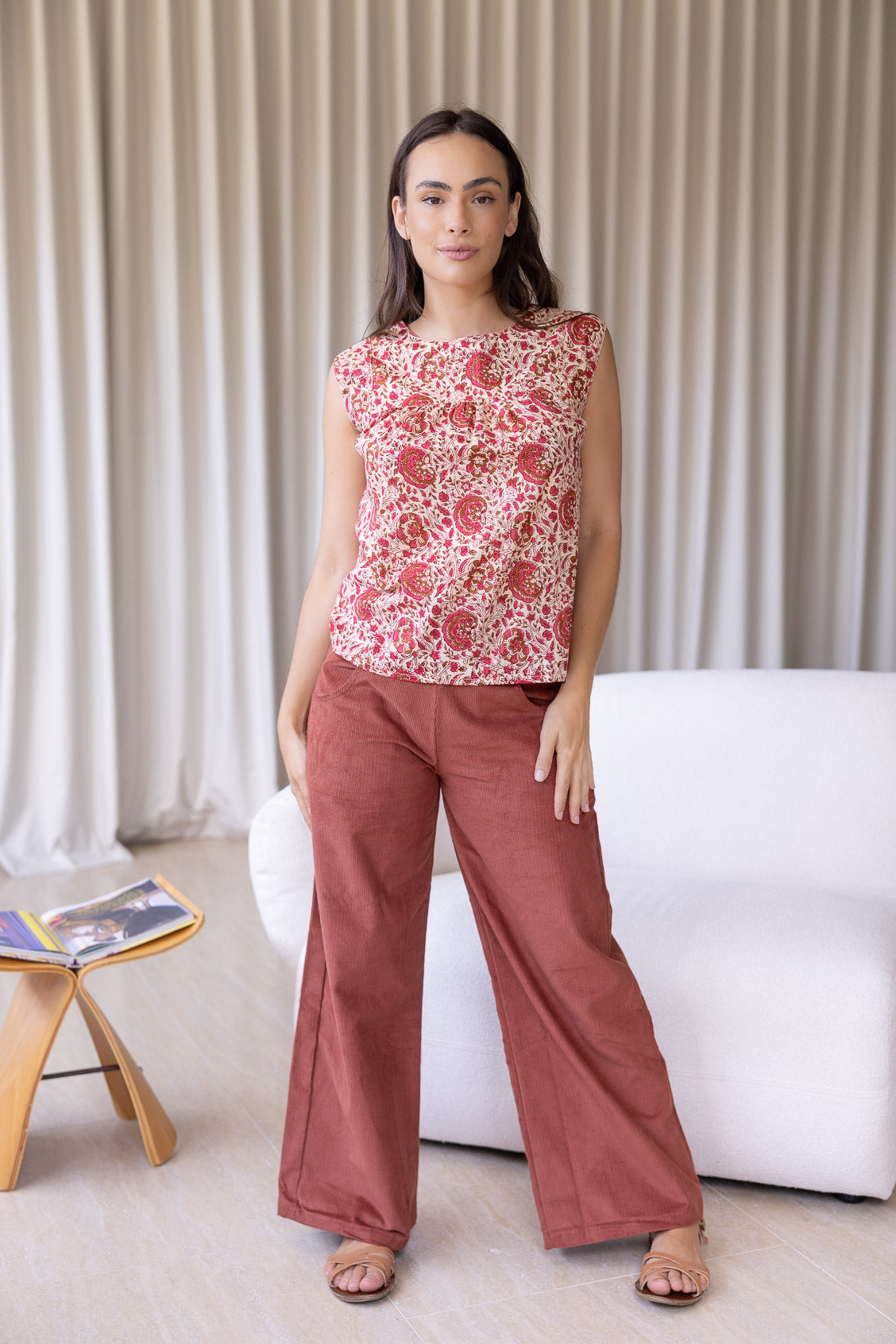 Woman wears cotton top with small gathers under the neckline yoke, both front and back, that gives this top a loose fit