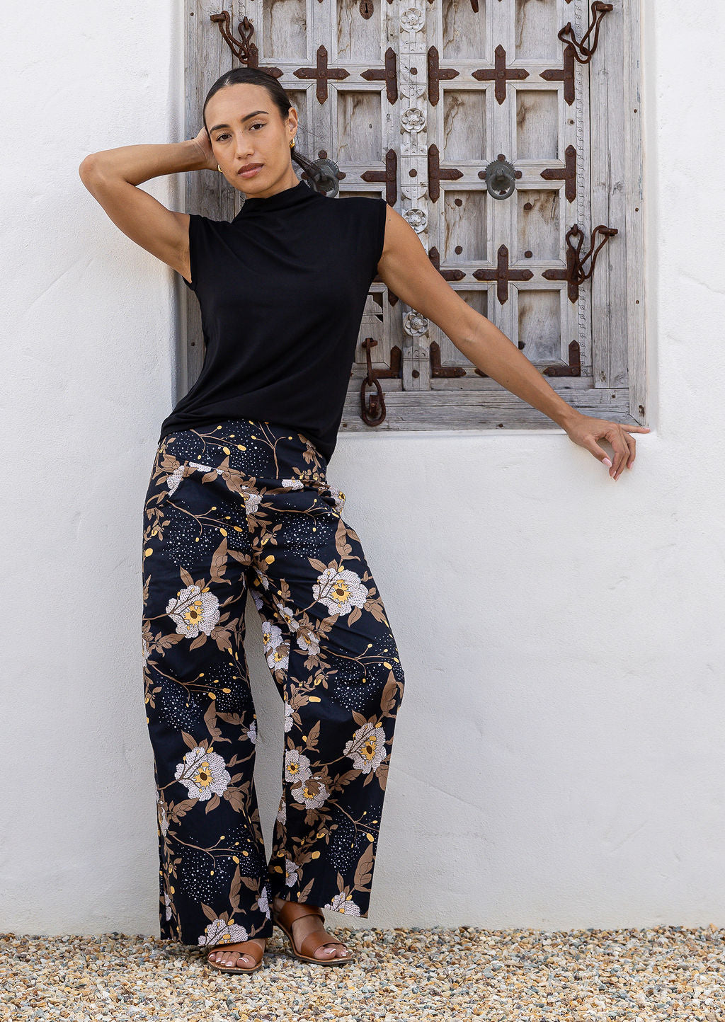 Model wears black based floral print wide leg cotton pants with pockets and side zip 