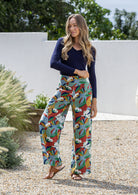 Model poses in floral cotton pants with side zipper, pockets and wide leg fit