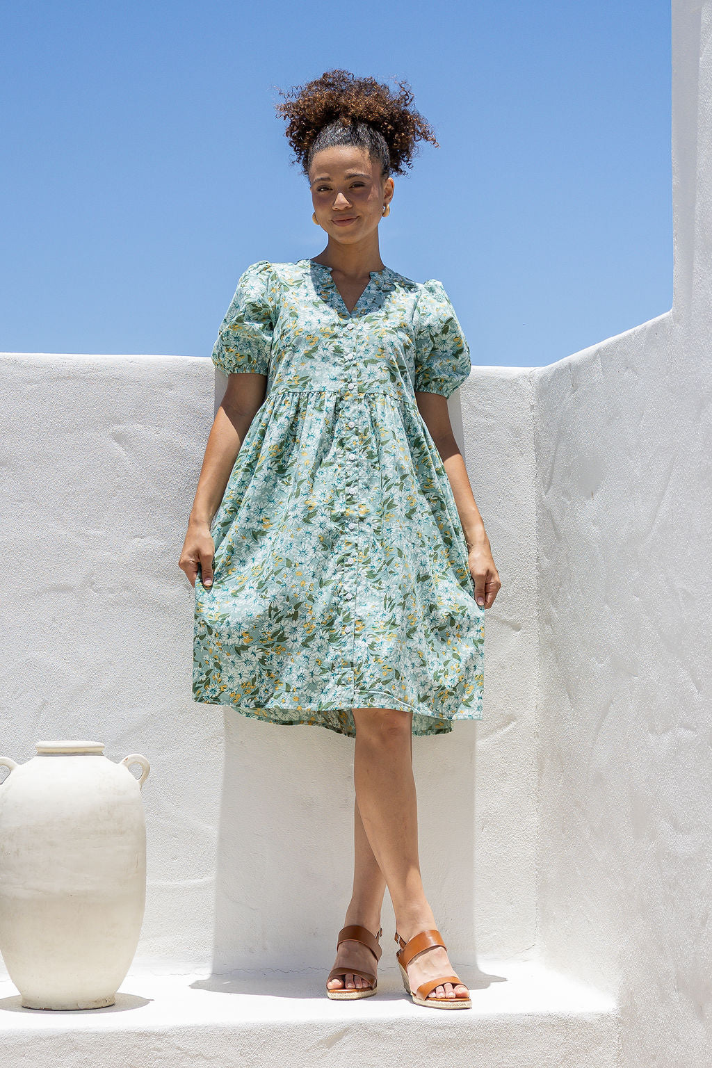 Woman wearing a knee length relaxed fit button through 100% cotton dress with elbow length sleeves