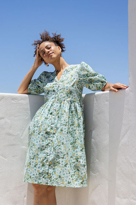 Woman wearing a 100% cotton floral dress against a clear blue sky