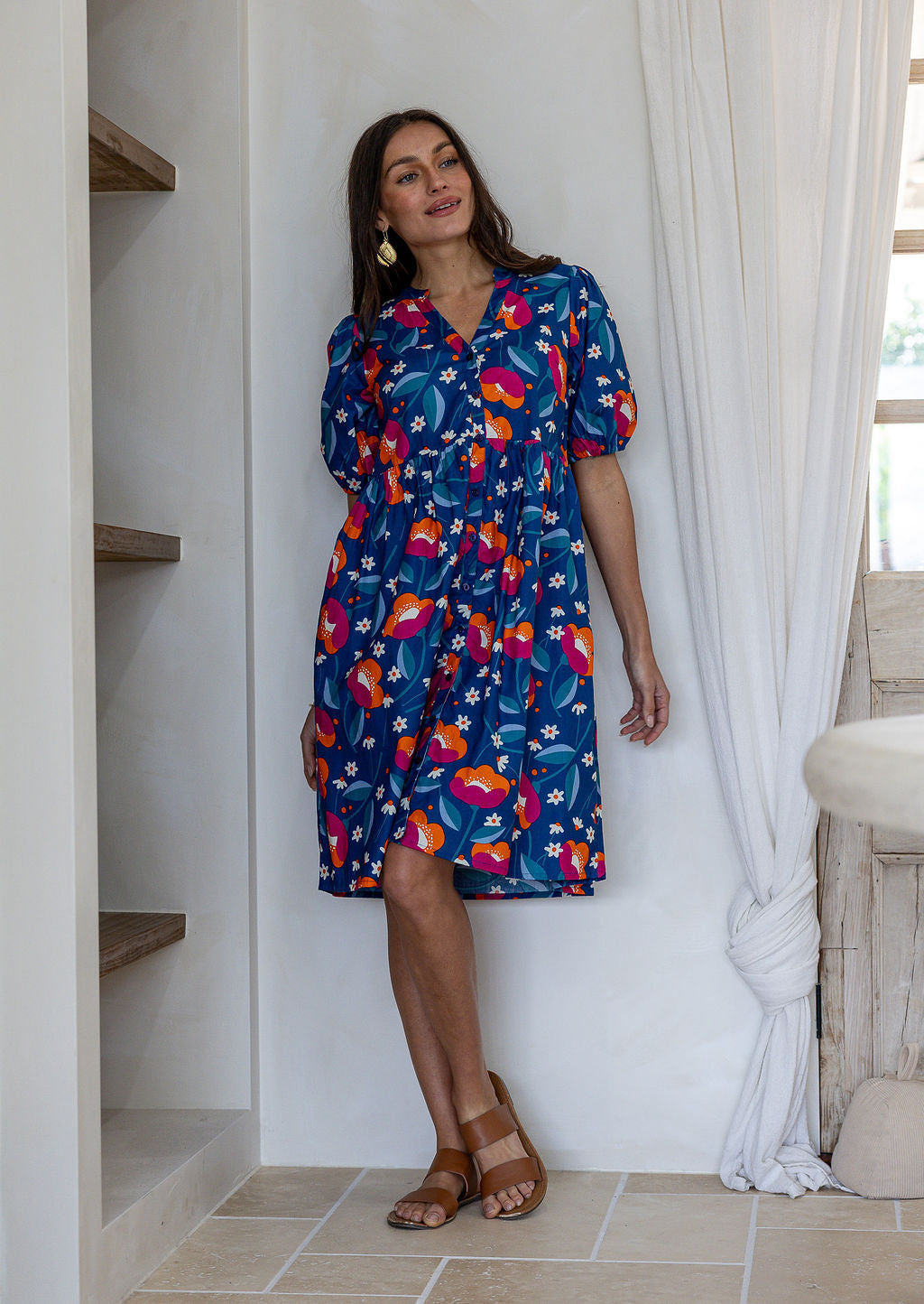 Woman wearing a knee length relaxed fit button through 100% cotton dress with elbow length sleeves