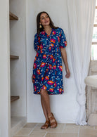 Woman wearing a knee length relaxed fit button through 100% cotton dress with elbow length sleeves