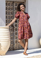 Woman wearing a warm toned Japanese style print dress with pink, maroon, brown, peach and khaki palette. 