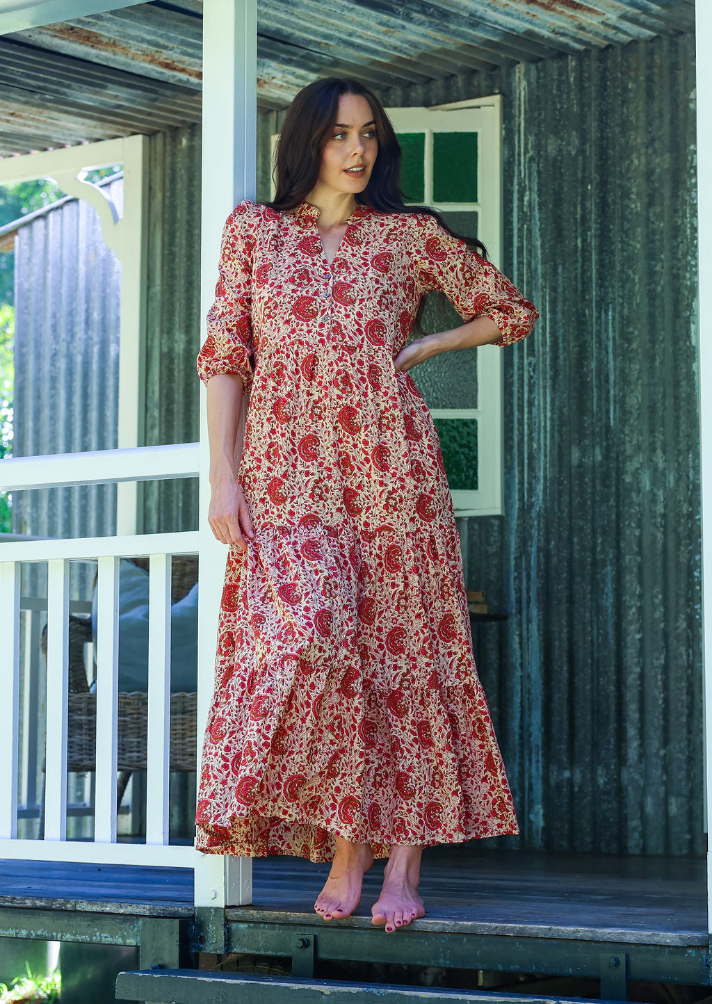 Woman wearing a 100% cotton tiered maxi dress in floral print with 3/4 sleeves, pockets and mandarin collar
