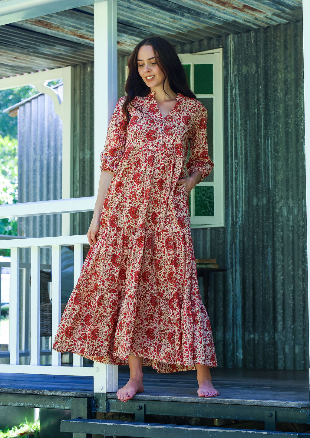 Woman poses in cream based floral cotton maxi dress with one hand in pocket
