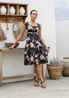 Model in knee length, black 100 percent cotton scoop neck retro style dress with pockets and cap sleeves 