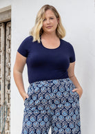 Woman wearing a scoop neck navy blue rayon fitted t-shirt.